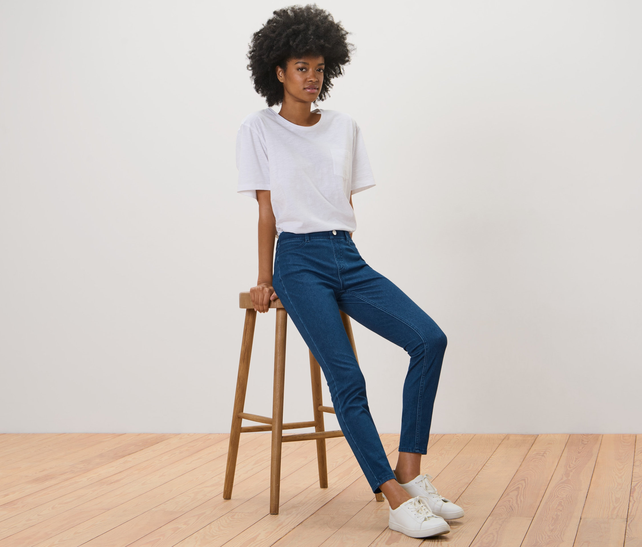Femme assise sur un tabouret portant un jegging.