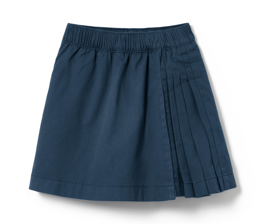 Une jupe kilt bleu marine pour tout-petits avec des plis sur un fond blanc.