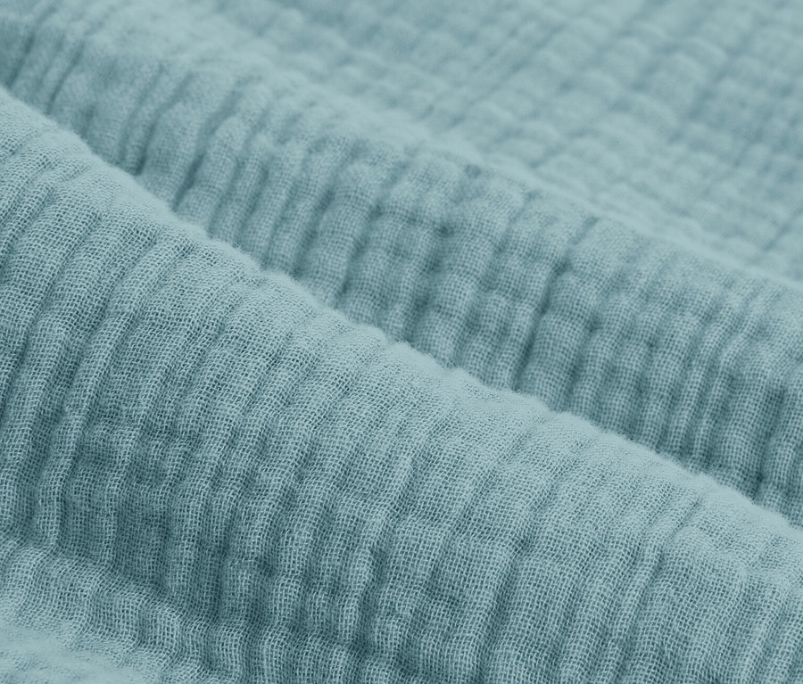 Gros plan d'une parure de lit en mousseline bleue de différentes tailles.