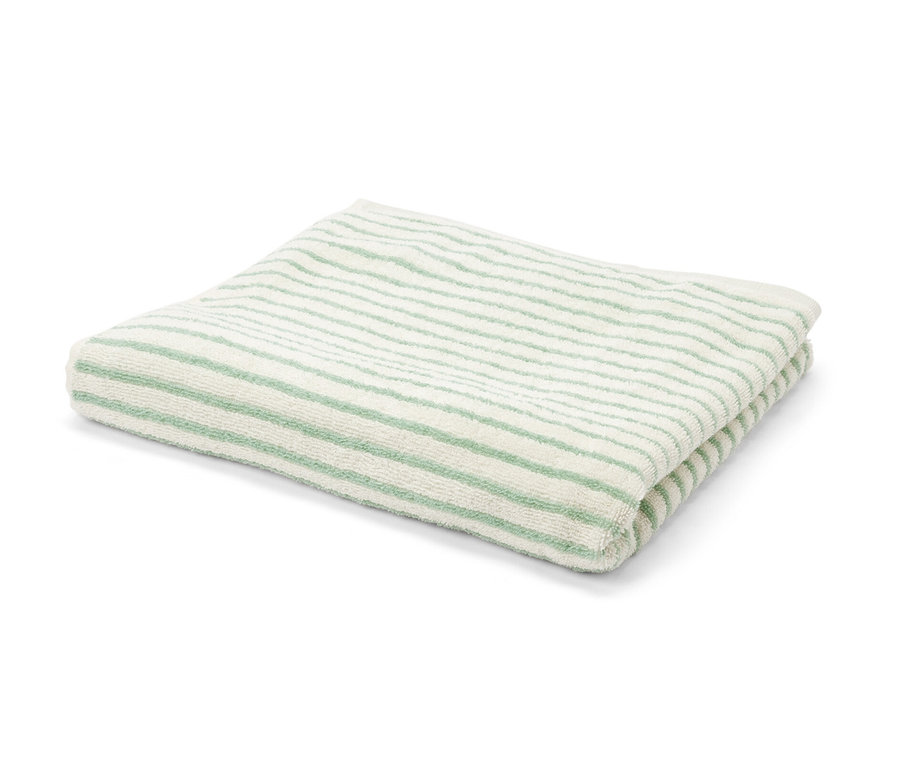 Un drap de bain rayé vert plié sur un fond blanc.