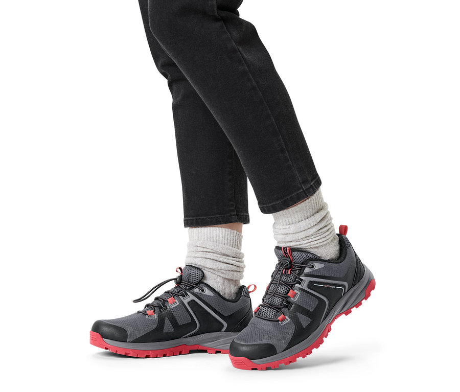 Jambes portant des chaussures de trekking grises.