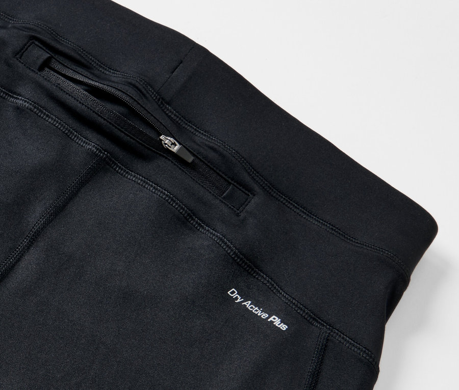 Détail d'un legging de sport noir avec poche zippée et inscription Dry Active Plus.