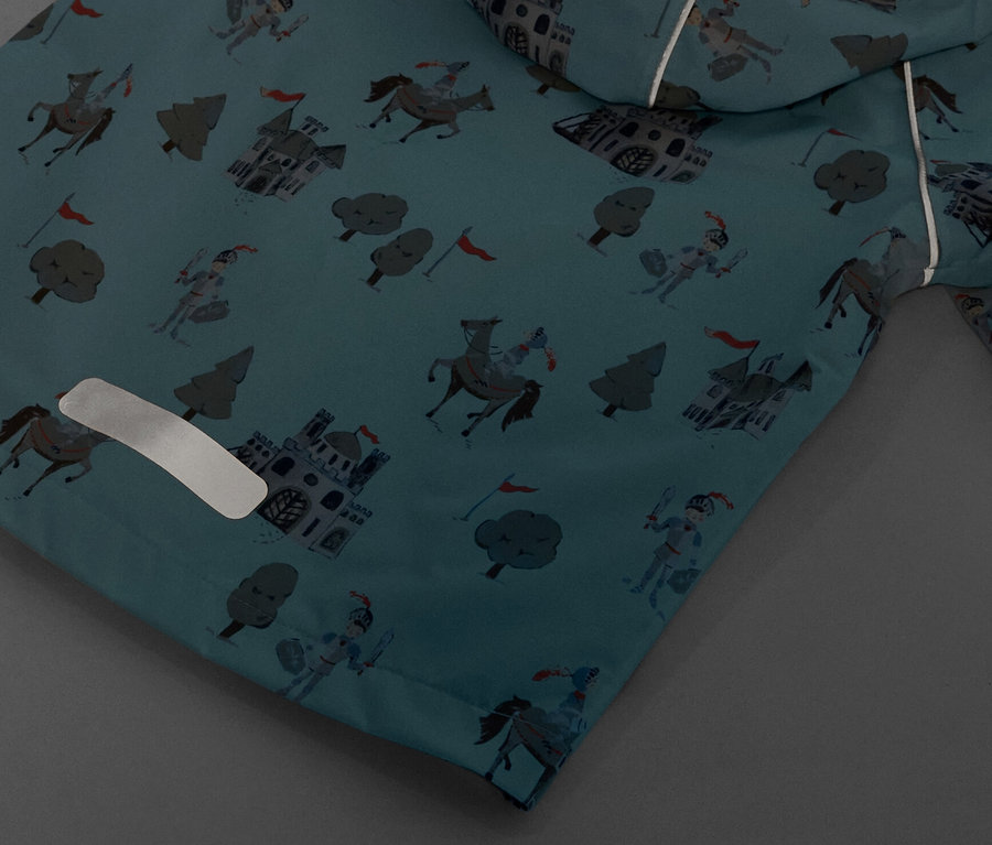 Détail d'une veste de pluie pour enfant avec motif de chevalier.