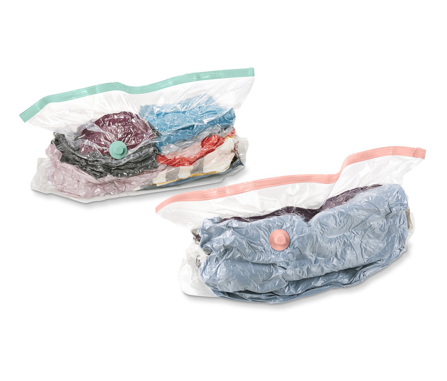 Deux sacs de rangement sous vide, cubes, remplis de vêtements, sur fond blanc.