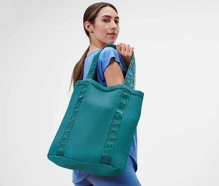Femme posant avec un sac de sport.