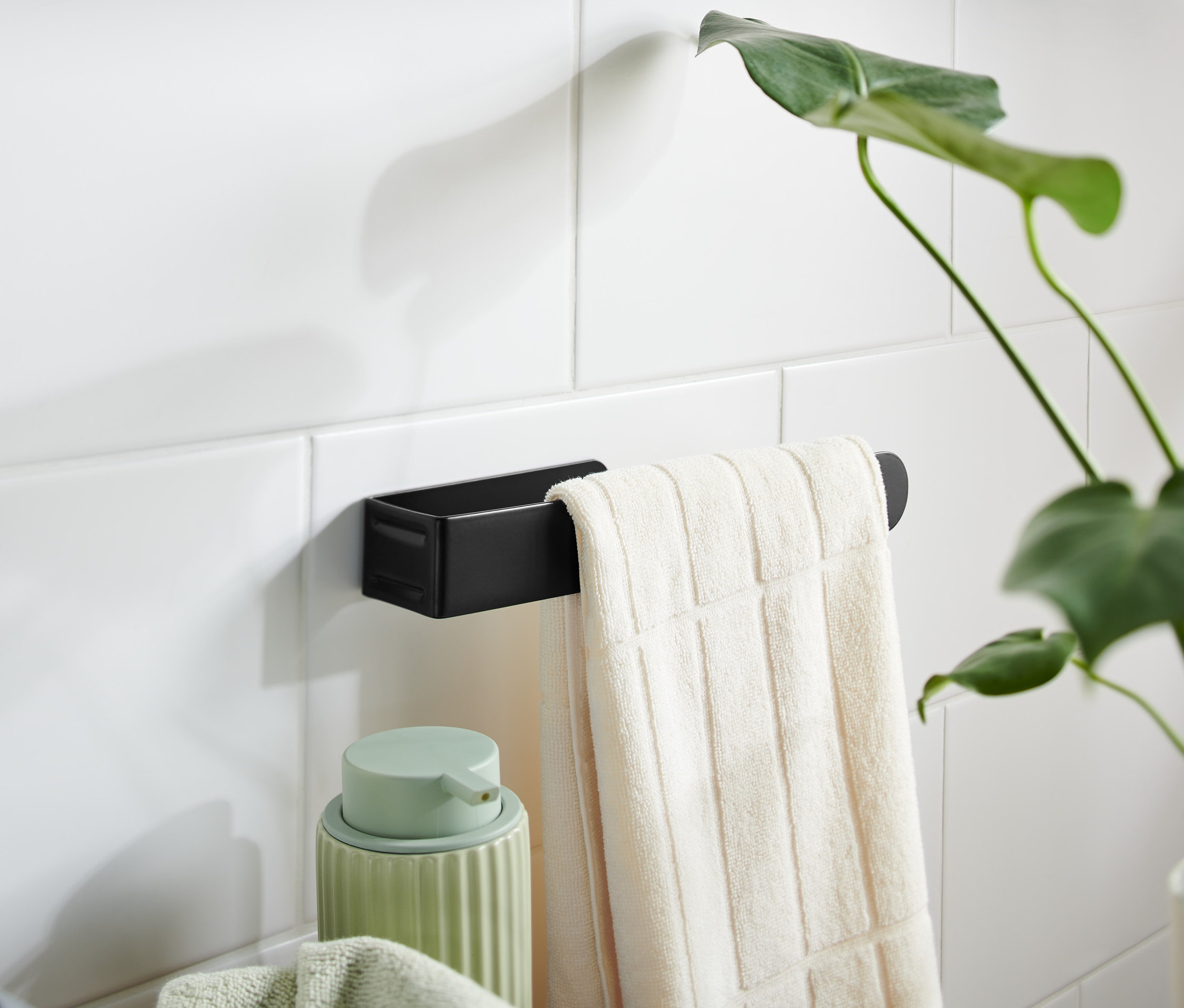 Une serviette blanche est suspendue à un porte-serviettes noir.