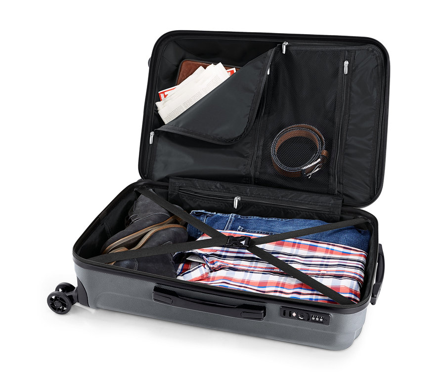 Valise rigide grise ouverte avec un lot de valises rigides, moyenne et grande. À l'intérieur, il y a des chaussures, un jean et une chemise.