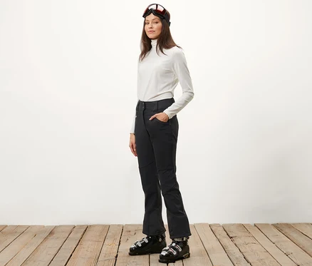 Femme posant en pantalon de jet-ski et chaussures de ski.