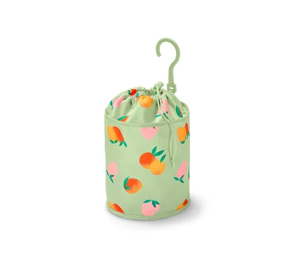 Un sac à pinces à linge vert avec un motif de fruits est suspendu.