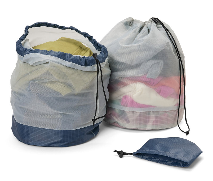 Deux sacs en filet pour l’extérieur, un ouvert et rempli de vêtements, l’autre fermé, et un sac vide.