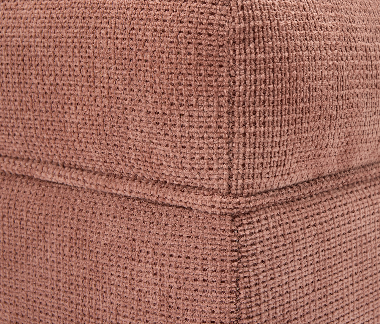 Détail d'un coin d'un cube en tissu marron.