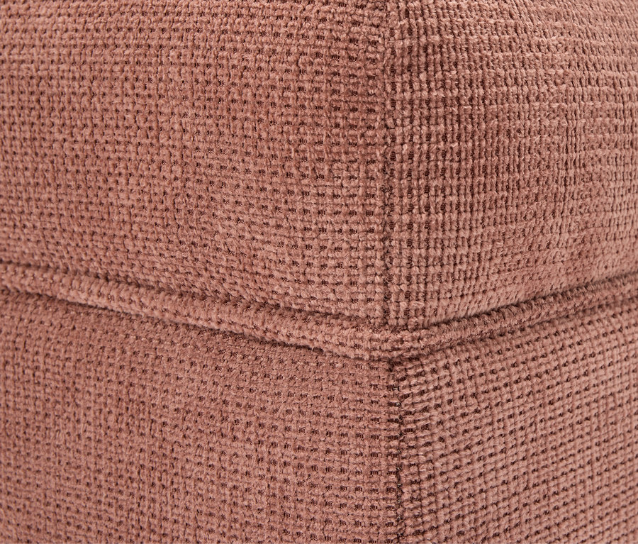 Détail d'un coin d'un cube en tissu marron.