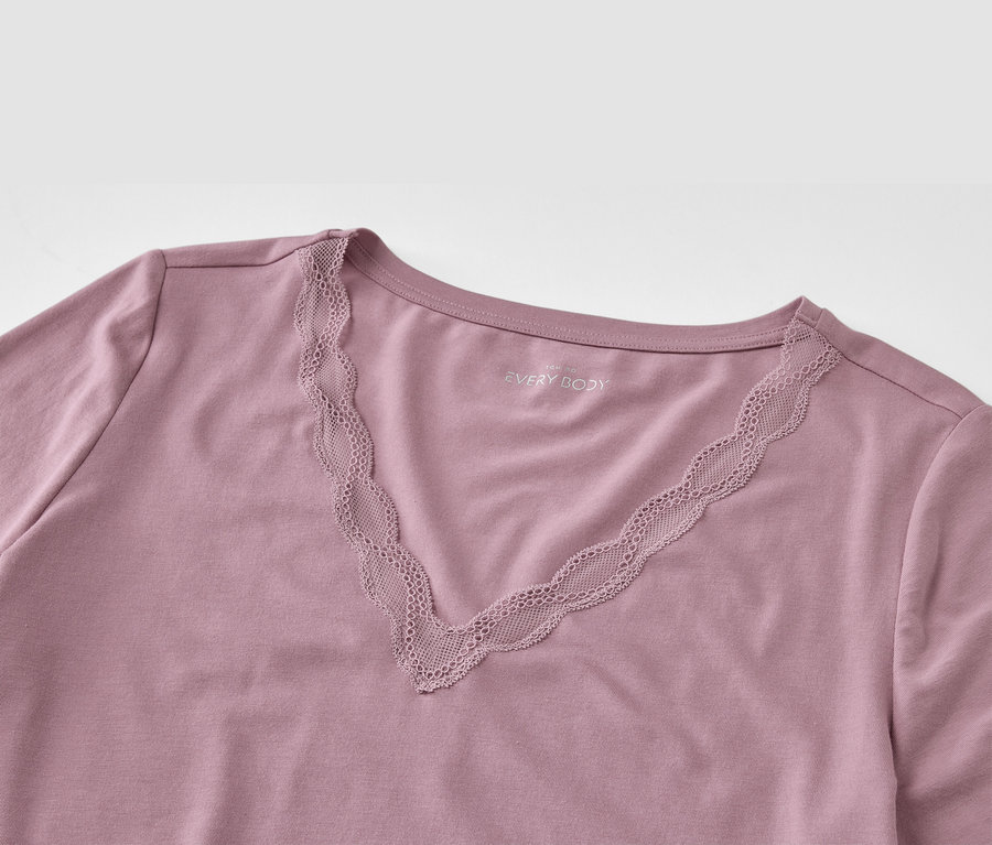 Détail d'un t-shirt violet avec encolure en V et dentelle.