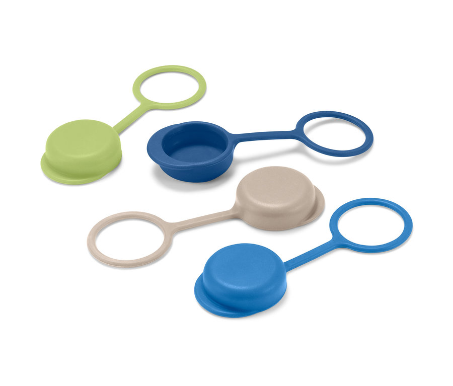 Quatre bouchons de bouteille en silicone vert, bleu foncé, beige et bleu clair.