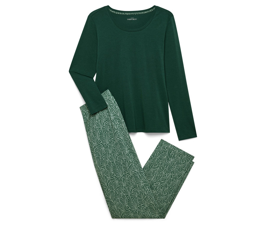 Un pyjama vert à manches longues et un pantalon à motif de feuilles vertes sont posés sur un fond blanc.
