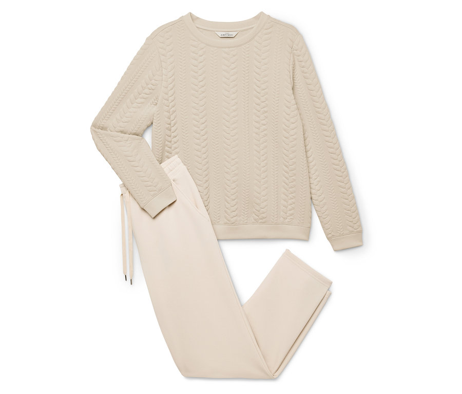 Survêtement d'intérieur beige composé d'un pull à torsades et d'un pantalon à cordon de serrage.