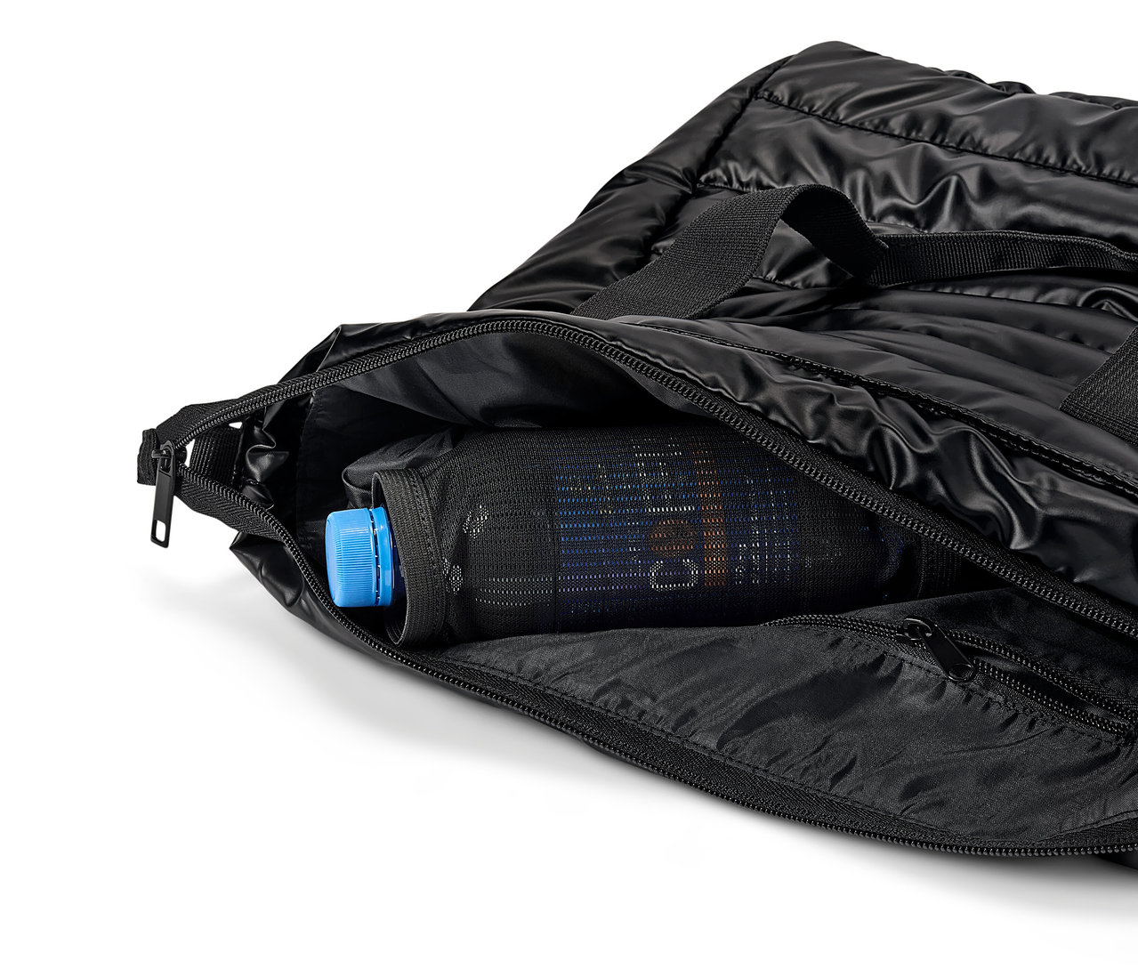 Sac noir matelassé avec fermeture éclair ouverte et une bouteille avec un bouchon bleu à l'intérieur d'une poche en filet.