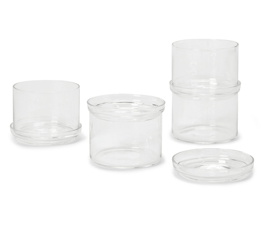 Quatre bocaux en verre de différentes tailles sur fond blanc.