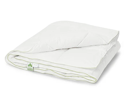 Couette blanche pliée et matelassée avec bordure vert clair.
