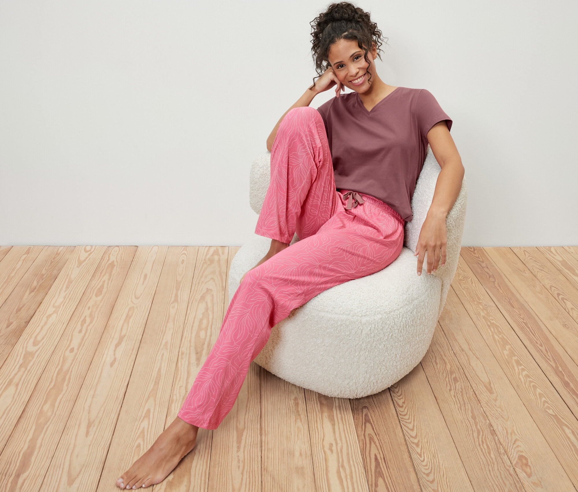 Une femme est assise dans un fauteuil et porte un pyjama.