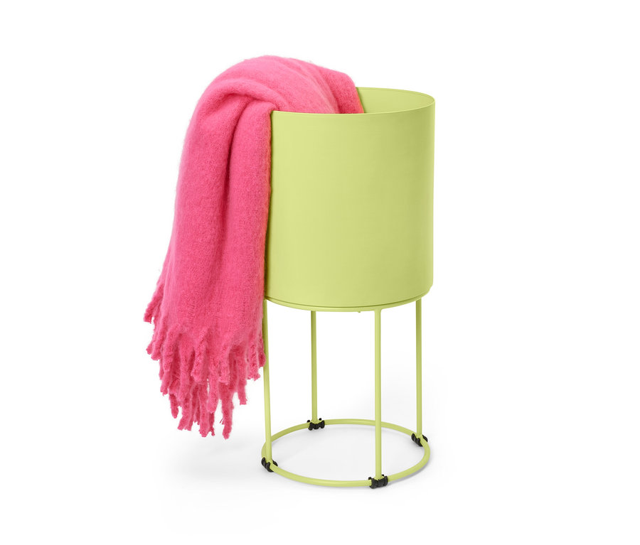 Couverture rose posée dans un cache-pot rond.