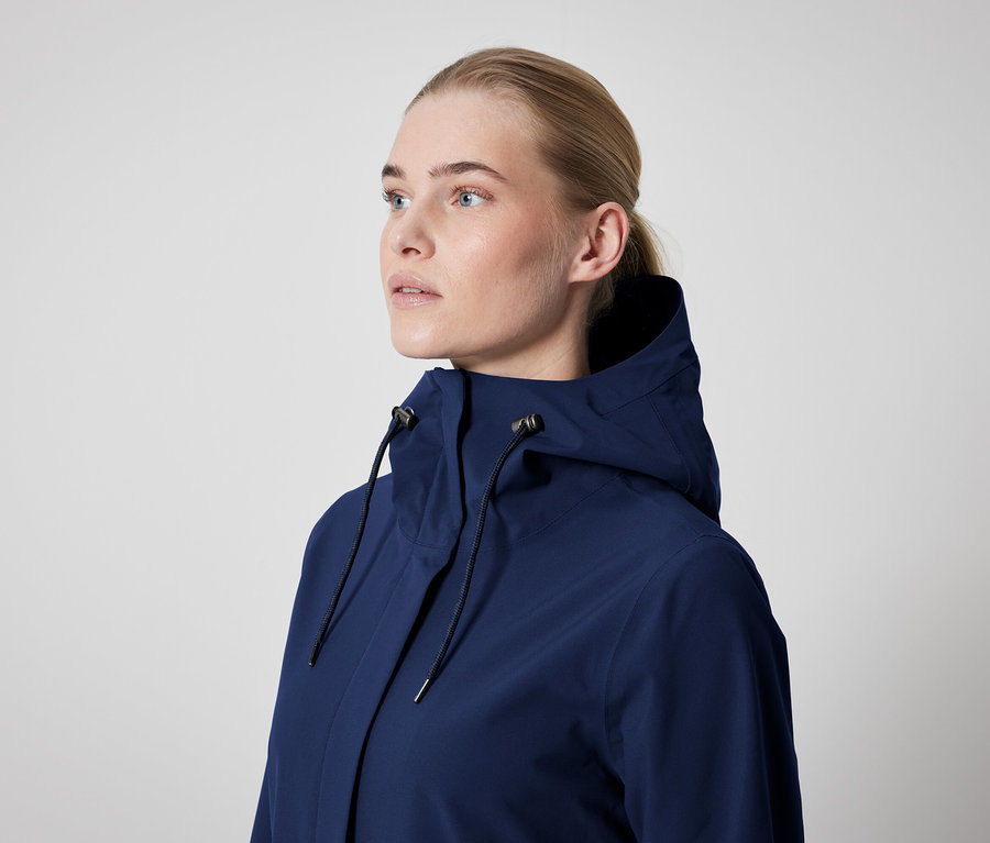 Une femme porte une veste bleu foncé à capuche.