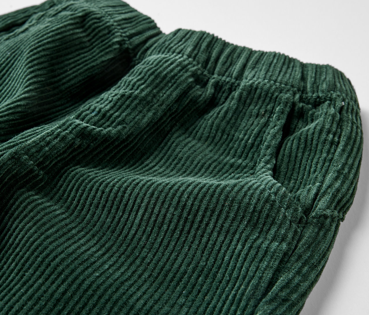 Gros plan sur un pantalon à enfiler vert pour enfants, coupe « Mika ».