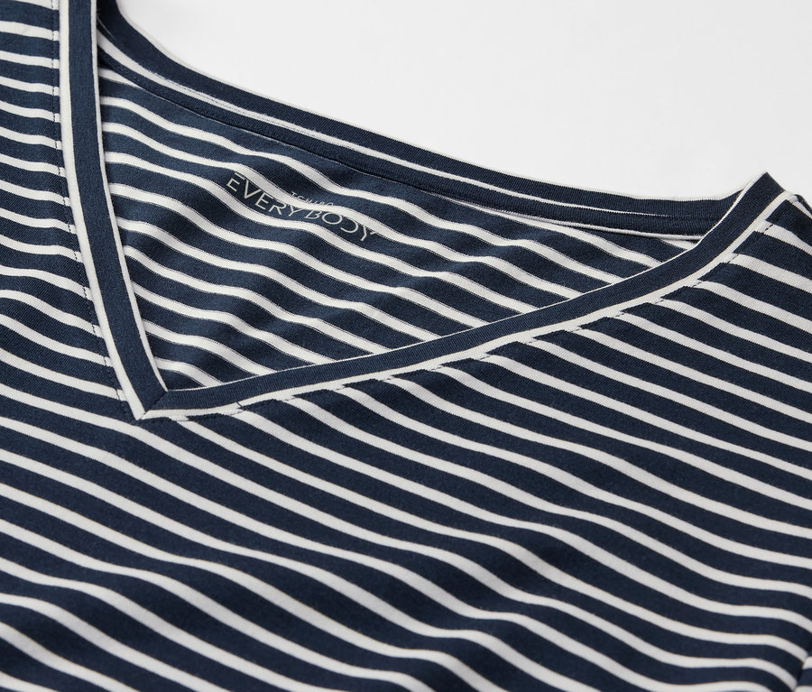 Gros plan d'un t-shirt rayé bleu et blanc avec un col en V.
