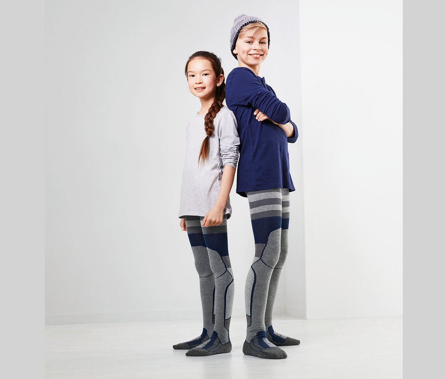 Deux enfants dos à dos portant des collants de ski.