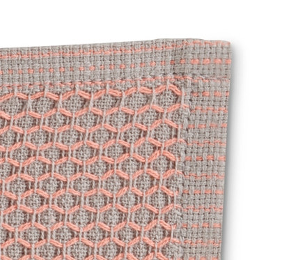 Gros plan sur un lot de 3 lavettes à motif gaufré rose et gris.