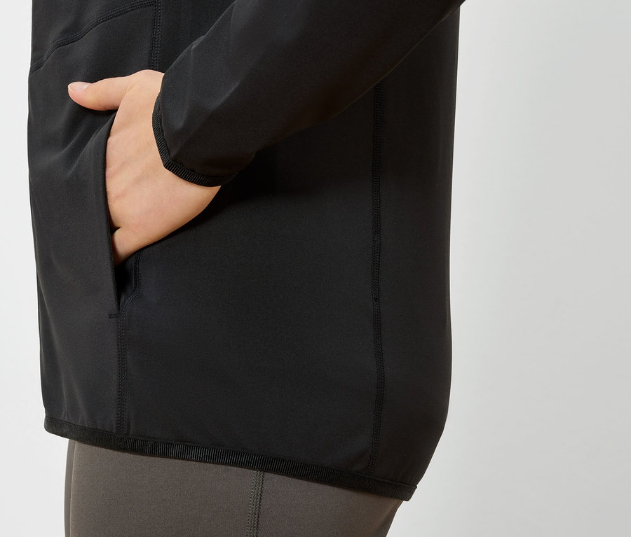 Main dans la poche d'une veste noire.