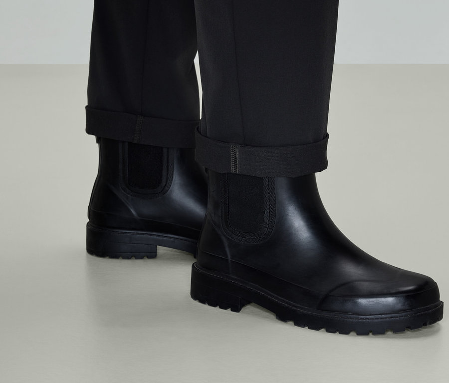 Bottes Chelsea en cuir noir avec pantalon.