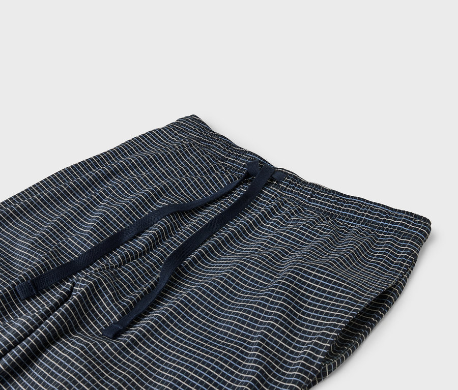 Gros plan d'un pantalon bleu marine à carreaux avec une taille élastique et un cordon de serrage.