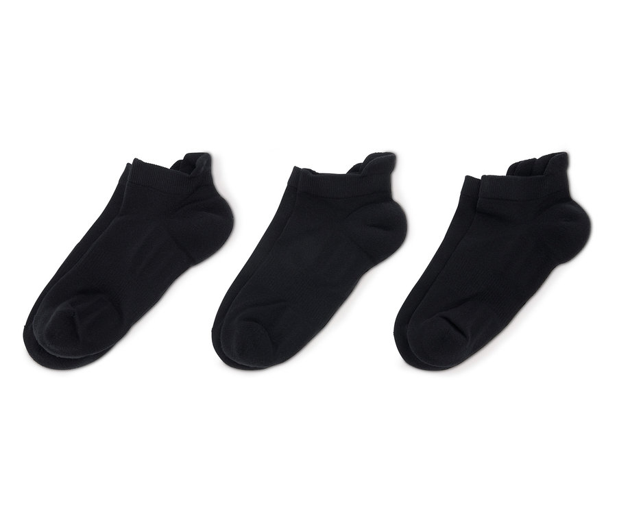 Trois paires de chaussettes basses noires sur fond blanc.
