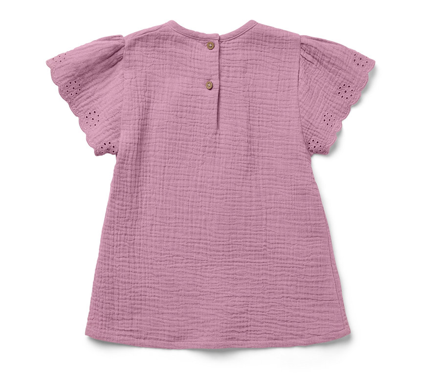 Blouse en mousseline rose pour enfant avec des manches courtes et des boutons dans le dos.