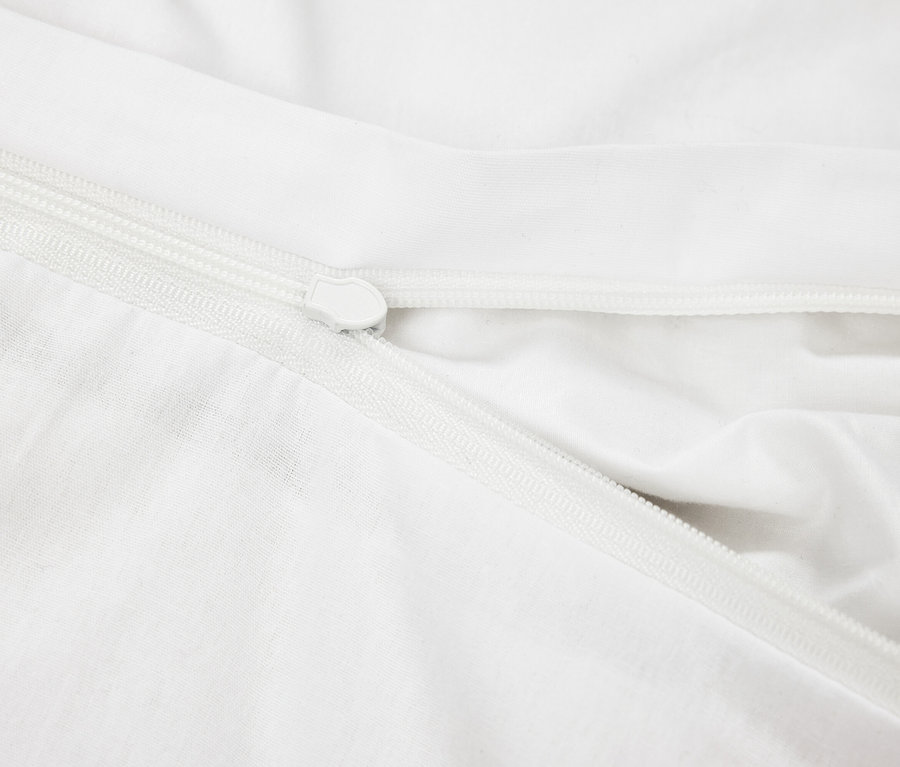 Gros plan d'une housse en tissu blanc avec une fermeture éclair blanche.