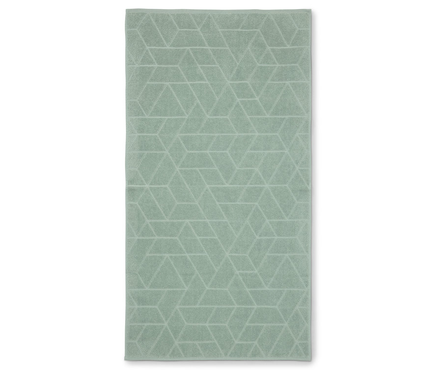 Une serviette vert clair avec un motif géométrique posée à plat sur une surface blanche.