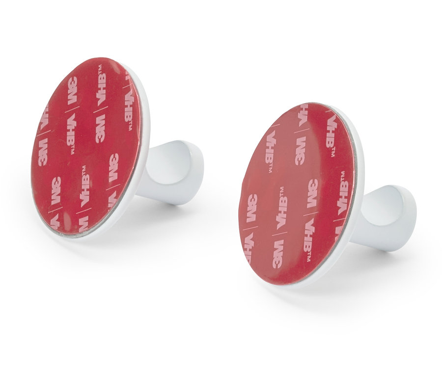 Deux crochets argentés avec une surface adhésive rouge et ronde 3M VHB™ sur un fond blanc.