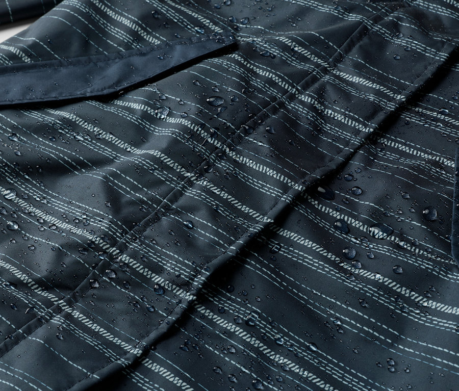 Gros plan d'une veste bleu marine rayée avec des gouttes d'eau et une poche.