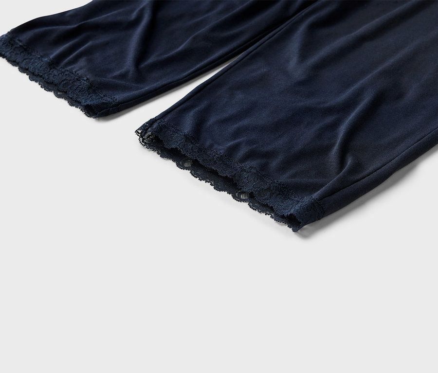 Gros plan d'un pantalon de pyjama bleu marine avec une bordure en dentelle