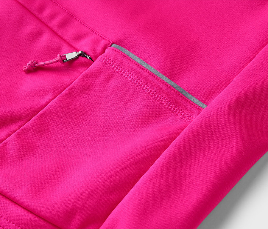 Gros plan d'une veste rose avec une poche zippée argentée.