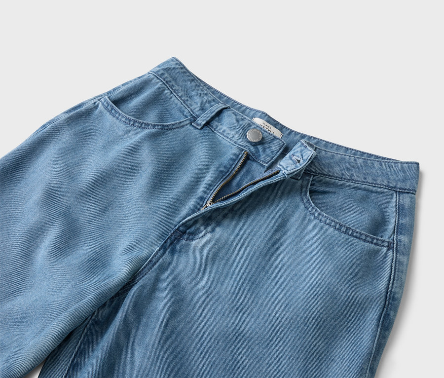 Gros plan d'un jean bleu clair avec une fermeture éclair ouverte.