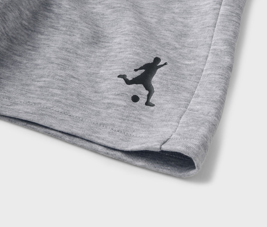 Gros plan sur un short gris avec une silhouette noire de joueur de football.