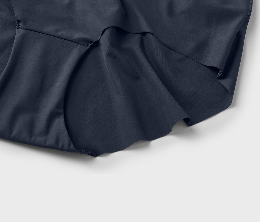 Gros plan d'un tissu bleu marine avec des plis sur un fond blanc.