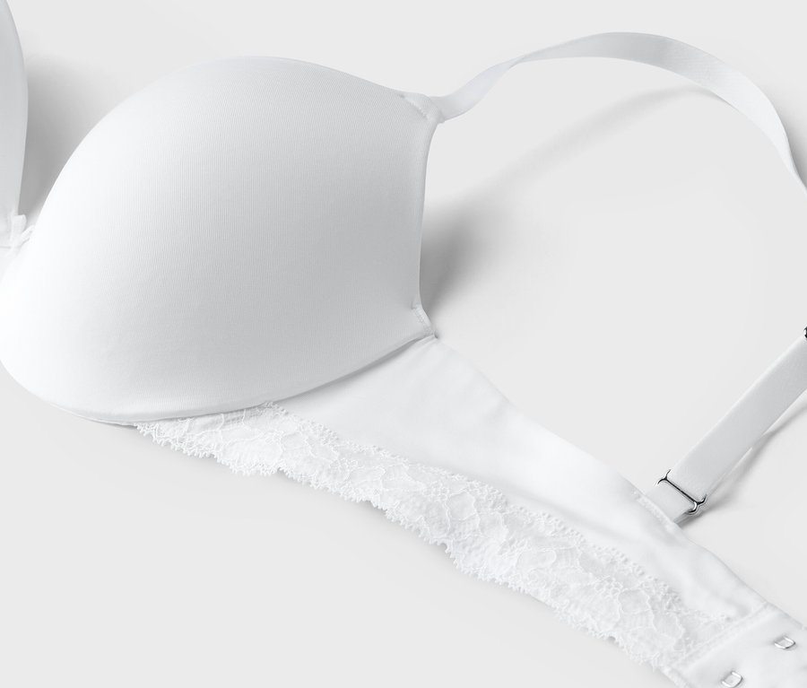 Vue détaillée d'un soutien-gorge blanc avec de la dentelle sur la bande inférieure.
