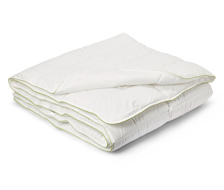 Couette blanche pliée et matelassée avec bordure verte.