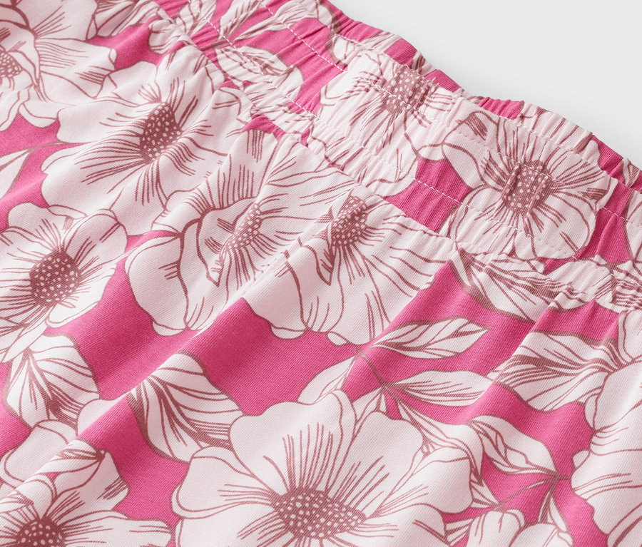 Gros plan d'un tissu rose à grand motif floral.