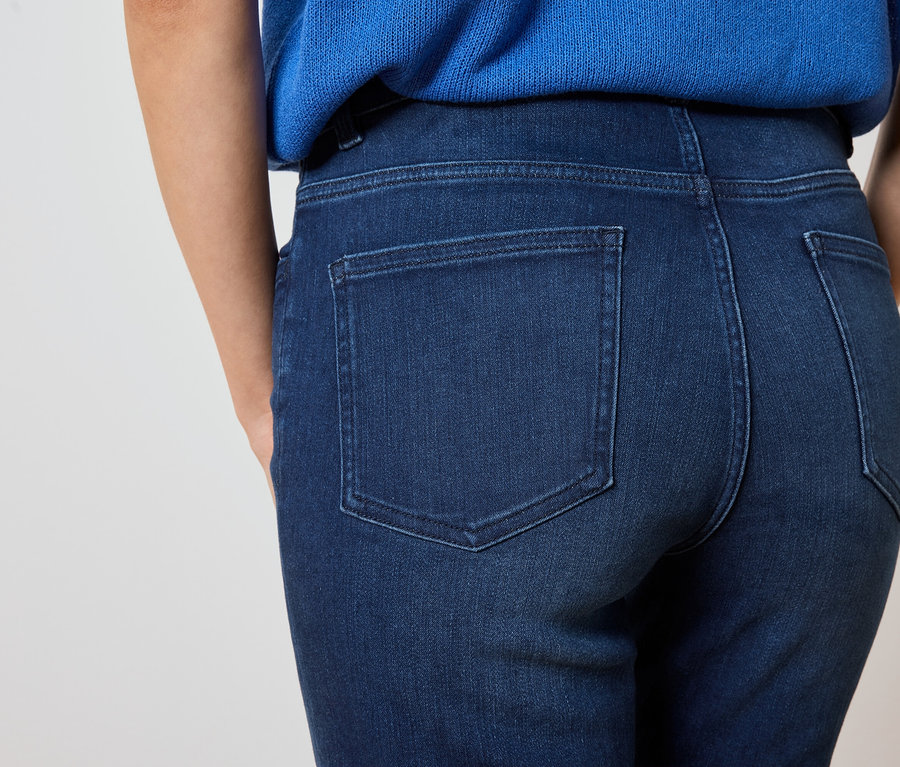 Gros plan sur le dos d'une femme portant un jean bleu foncé et un haut bleu.