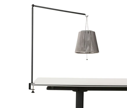 Une lanterne solaire à accu avec support de table est suspendue à un cadre noir fixé à un plateau de table.