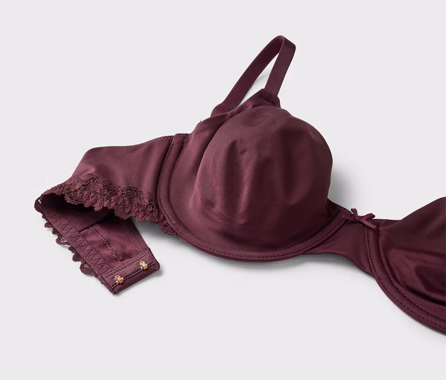 Gros plan d'un soutien-gorge aubergine à armatures avec bretelles réglables sur fond blanc.